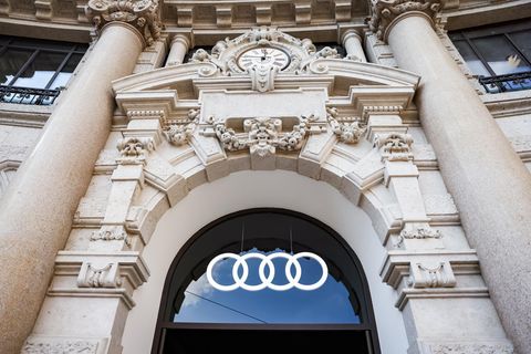 Audi-Symbol leuchtet an einer Hausfassade