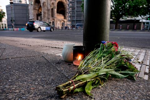 Kerzen und ein Blumenstrauß liegen auf dem Bürgersteig an der Tauentzienstraße