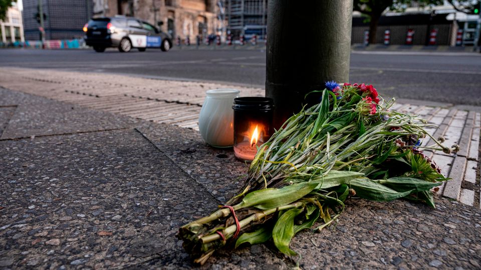 Kerzen und ein Blumenstrauß liegen auf dem Bürgersteig an der Tauentzienstraße