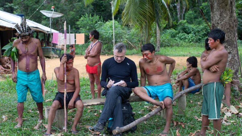 Der britische Journalist Dom Phillips macht umgeben von Indigenen Notizen