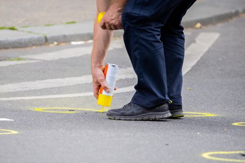 Nach einem tödlichen Zwischenfall werden auf der abgesperrten Straße Spuren markiert.