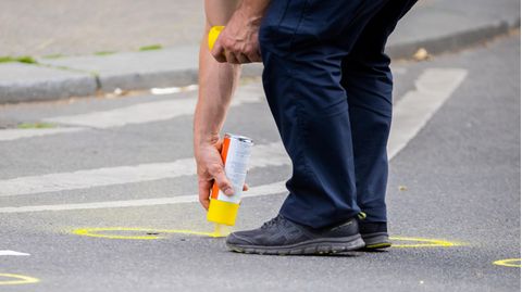 Nach einem tödlichen Zwischenfall werden auf der abgesperrten Straße Spuren markiert.