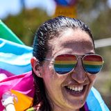 Eine Frau mit Regenbogen-Brille und -Fahne
