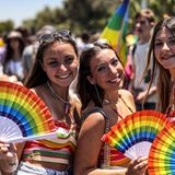 Drei Frauen mit Regenbogen-Fächern