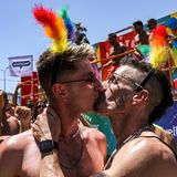 Zwei Männer küssen sich unter den Teilnehmenden der Tel Aviv Pride