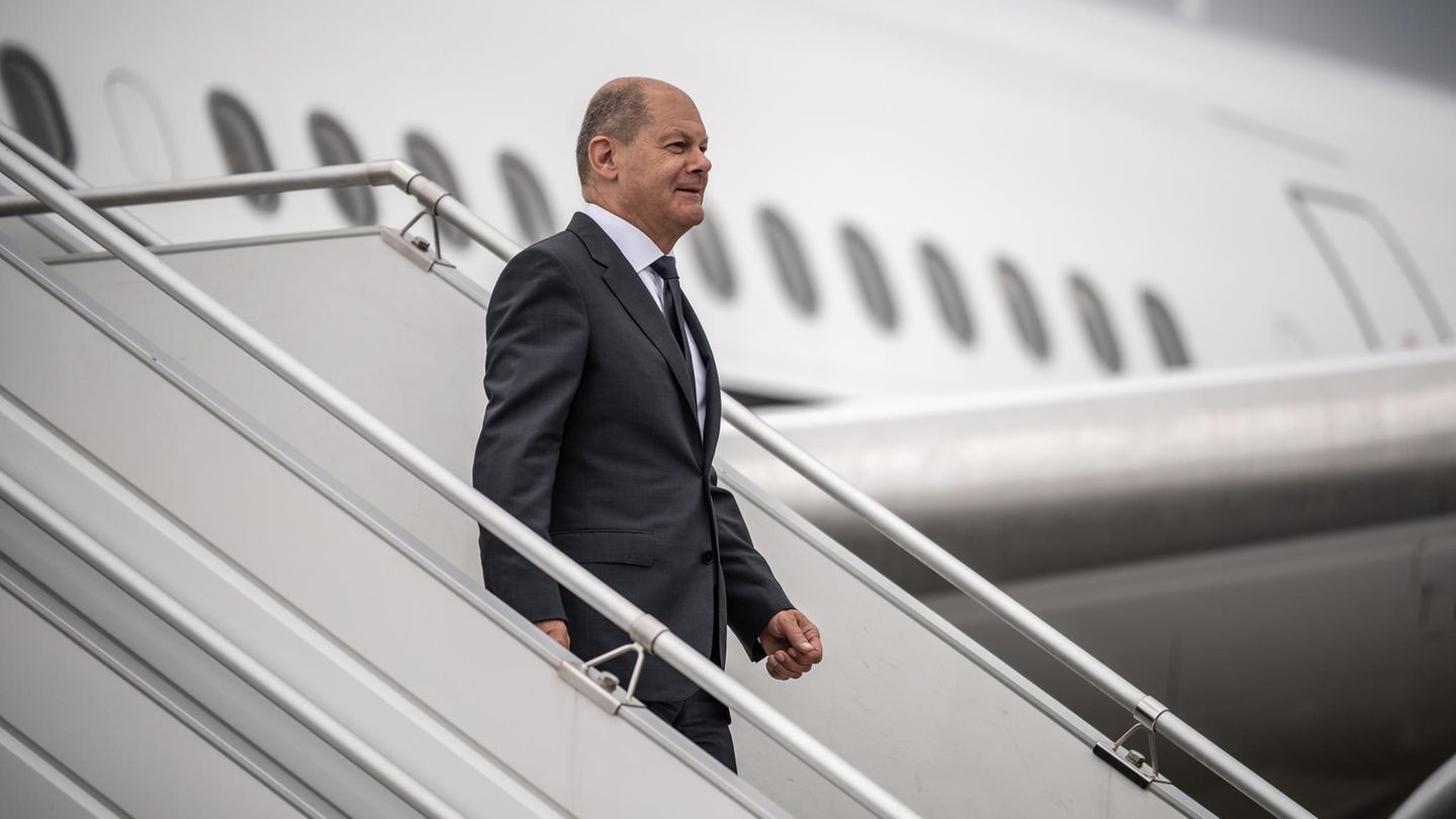 Olaf Scholz geht die Gangway an einem Flugzeug runter