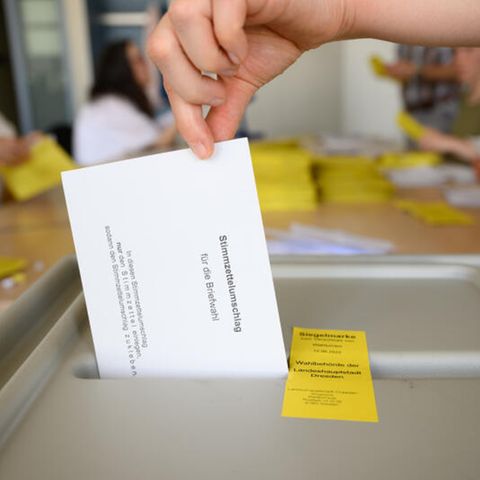 Sachsen Landratswahl: Eine Frau wirft einen Wahlumschlag in die Urne