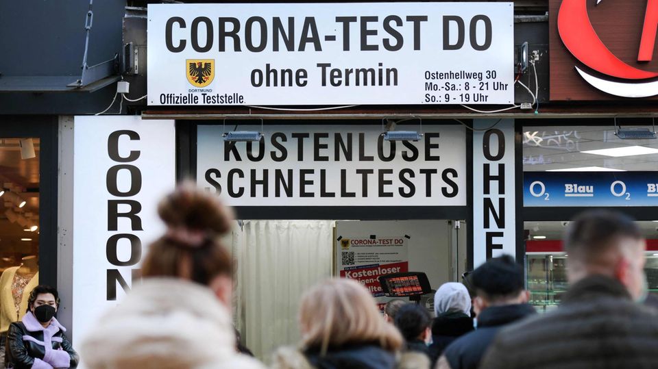 Menschen stehen vor einem Corona-Testzentrum in der Schlange