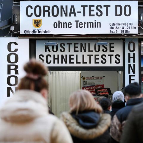 Menschen stehen vor einem Corona-Testzentrum in der Schlange