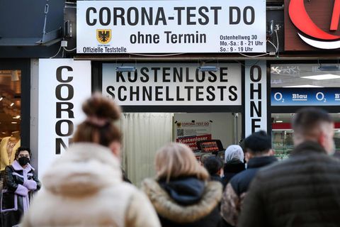 Menschen stehen vor einem Corona-Testzentrum in der Schlange