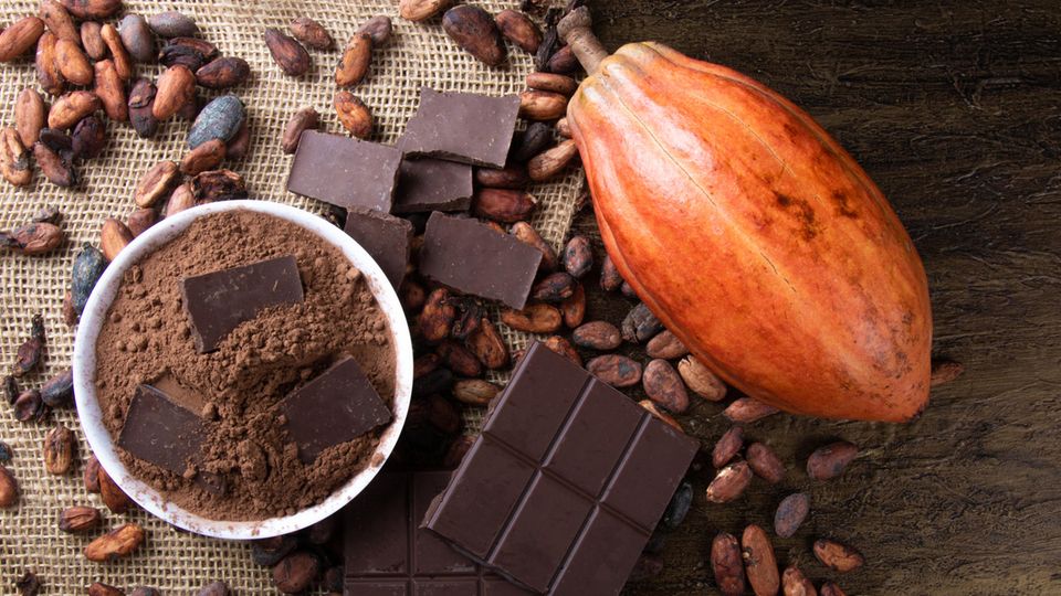 Kakaobohnen und Schokolade liegen auf einem Tisch