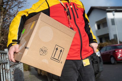 Ein DHL-Bote mit einem Paket
