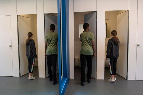 Mädchen und Jungen gehen nebeneinander in Klokabinen