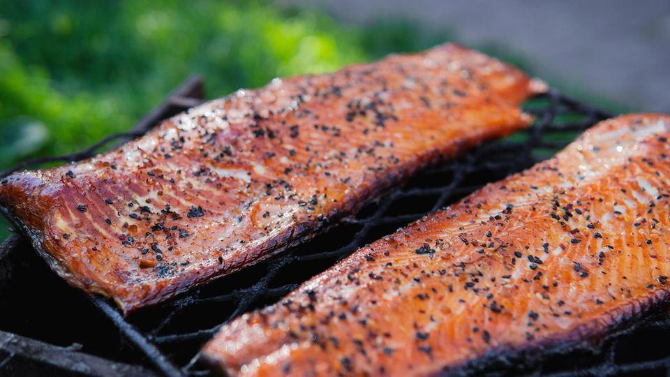 Ein Mann räuchert Fisch im Garten