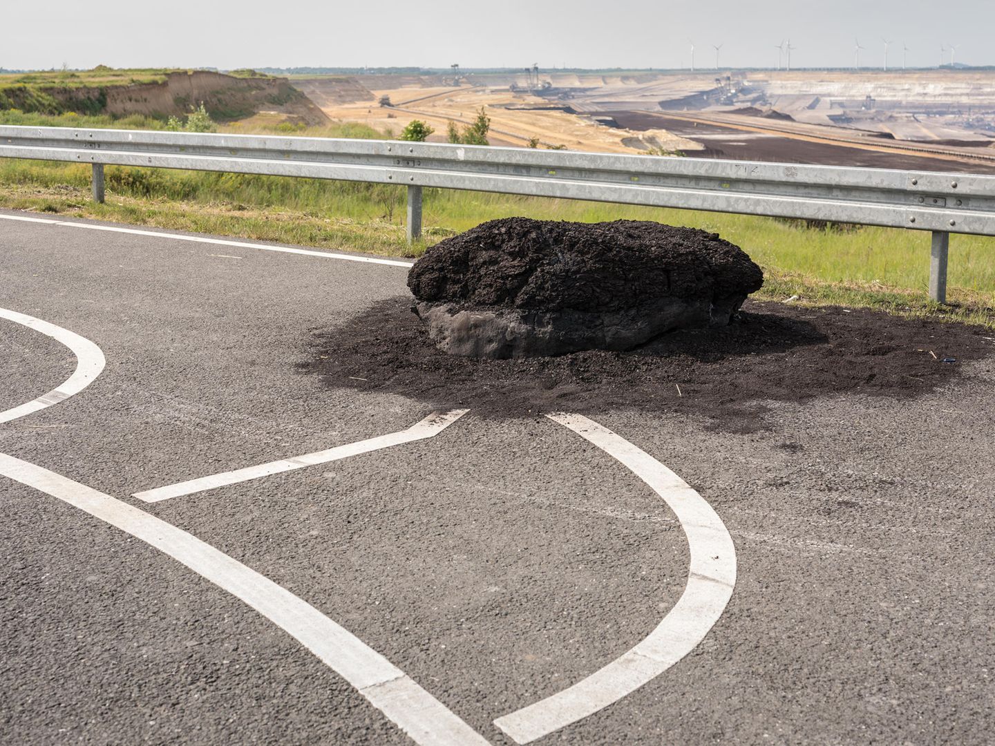 Ein Braunkohle-Monolith liegt auf einem Parkplatz