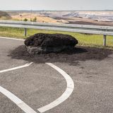 Ein Braunkohle-Monolith liegt auf einem Parkplatz
