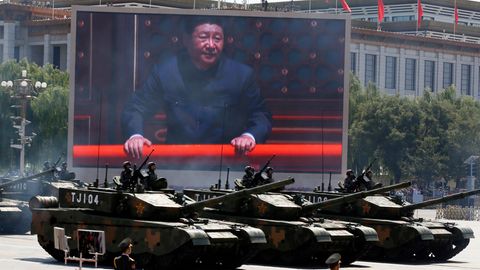 Xi Jinping (M) ist auf einem Bildschirm zu sehen während chinesische Kampfpanzer an einer Parade teilnehmen