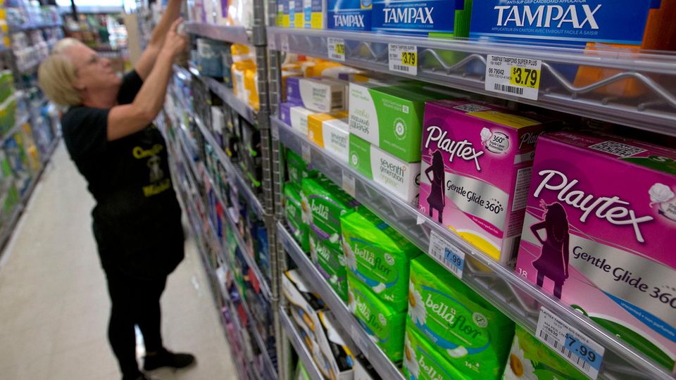 Drogerieverkäuferin füllt in den USA ein Regal mit Tampons aus