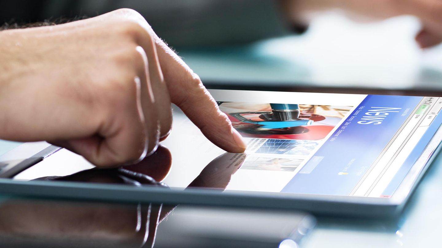 Eine Hand scrollt auf dem Tablet auf einer Nachrichten-Seite