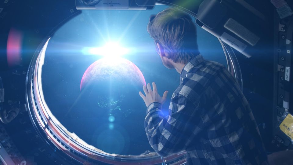 Ein Weltraumtourist blickt aus dem Fenster einer Weltraumkapsel