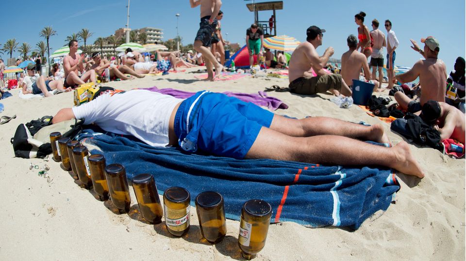 Ein deutscher Tourist schläft am Strand von Mallorca seinen Rausch aus