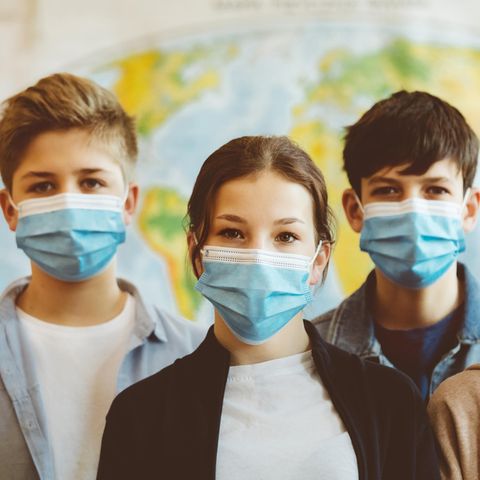 Vier Schülerinnen und Schüler mit Maske während der Pandemie