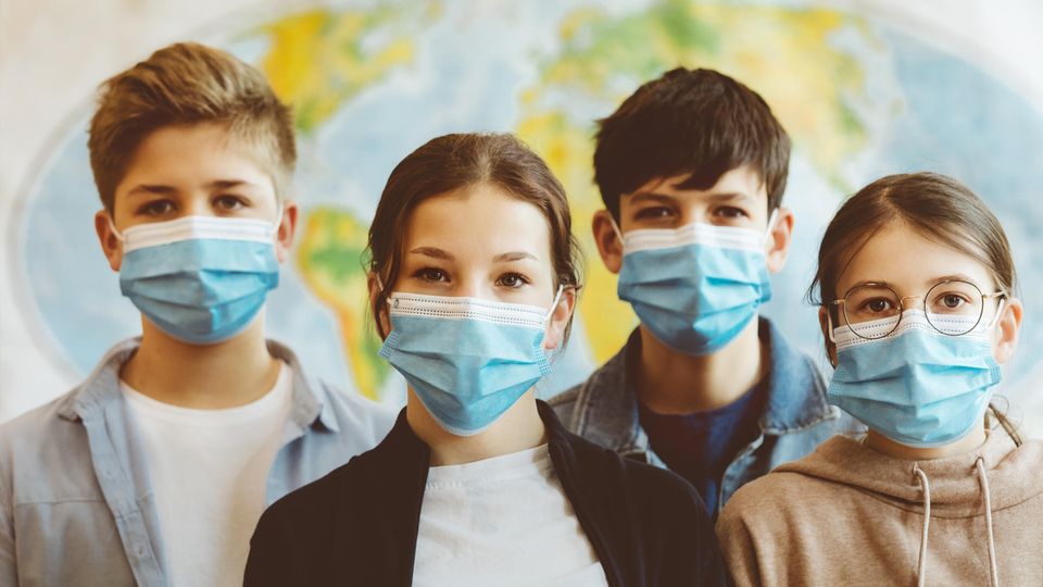 Vier Schülerinnen und Schüler mit Maske während der Pandemie
