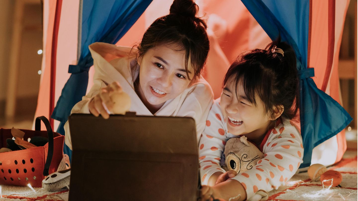 Eine Mutter und ihre kleine Tochter spielen auf einem Tablet