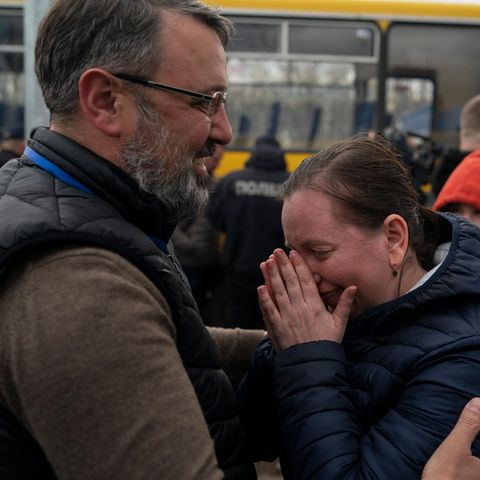 Eine Frau steht einem Mann gegenüber und wischt sich Tränen aus dem Gesicht
