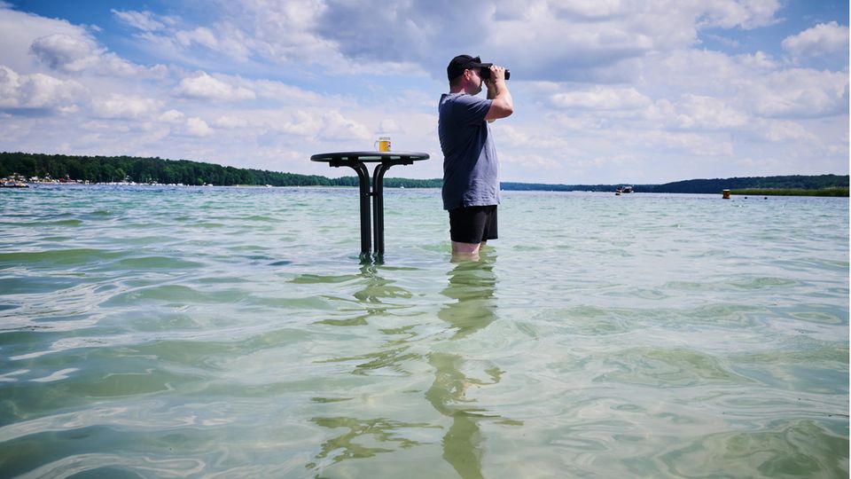 Hitzewelle Deutschland: Ein Mann kühlt sich mit Bier im Wasser ab