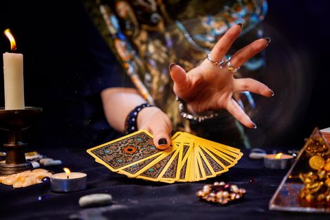 Eine Frau hält einen Stapel Tarotkarten in Ihrer Hand.