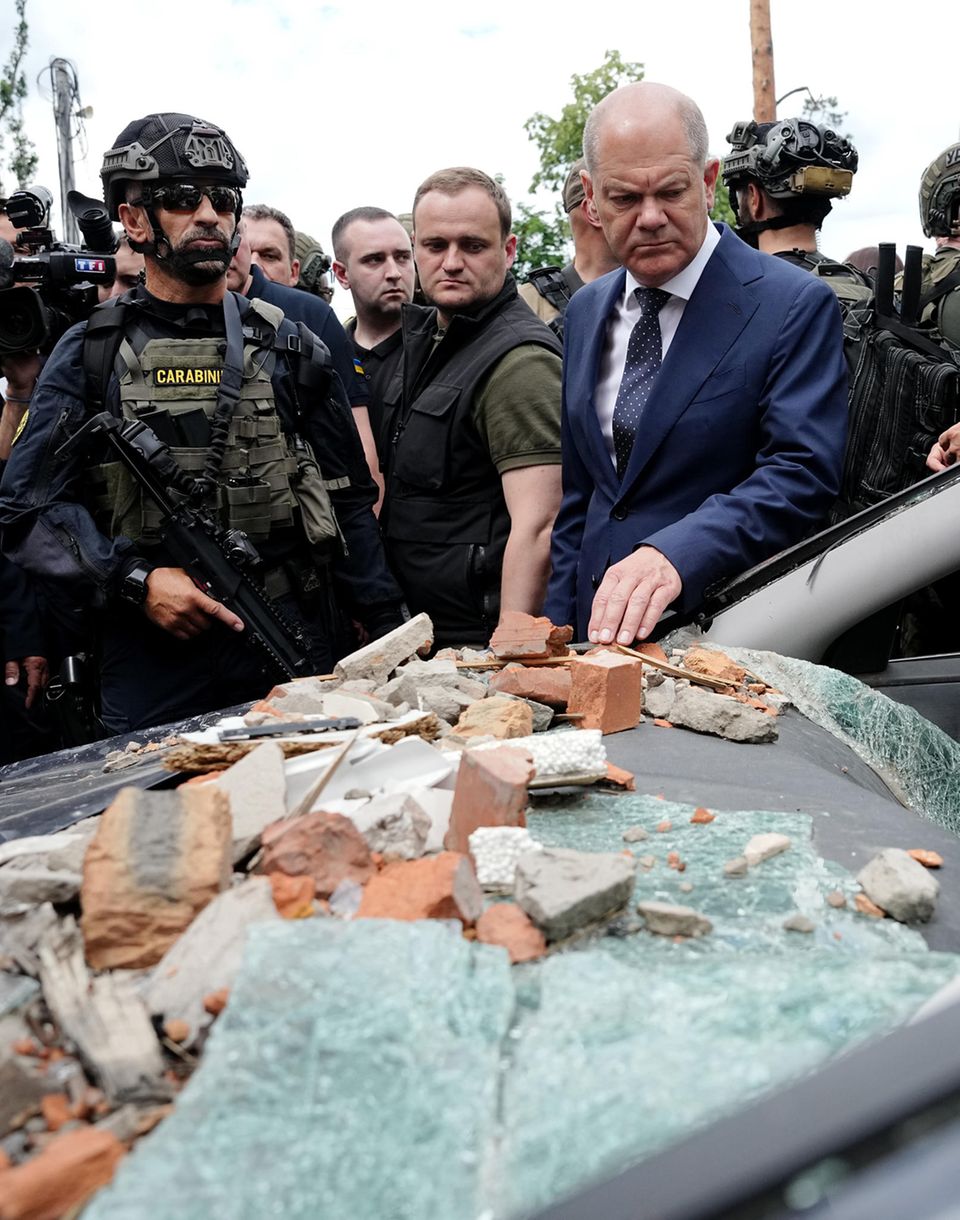 Chancellor Olaf Scholz (r, SPD) looks at a badly damaged car in Irpin in the Kyiv region Chancellor Olaf Scholz (r, SPD) looks at a badly damaged car in Irpin in the Kyiv region