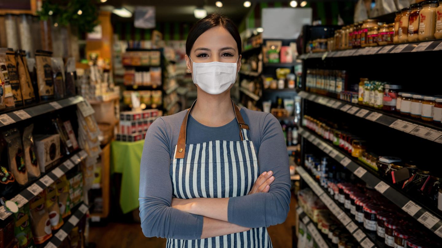 Maske zum Schutz gegen das Coronavirus Eine Frau trägt ihre Maske im Supermarkt