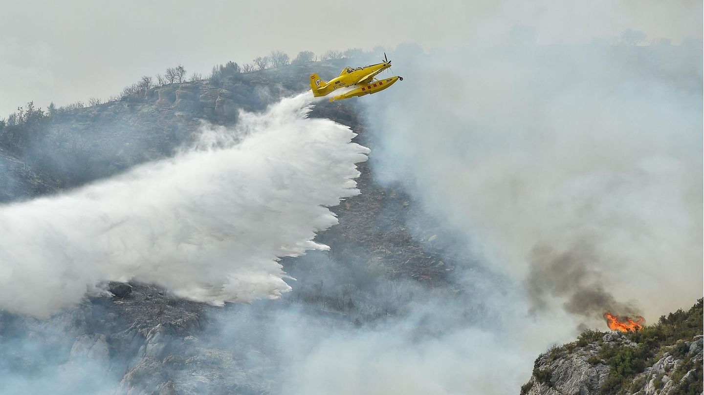 Extremwetter: In der Nähe von Artesa de Segre, Katalonien, wirft ein Löschflugzeug Wasser über einem Waldbrand ab. Es ist nicht das einzige Waldgebiet in Spanien das infolge der Hitze in Flammen steht. Die Zunahme der Hitzewellen ist laut Wissenschaftlern eine direkte Folge der globalen Erwärmung. Dabei nehmen sowohl Intensität als auch Dauer und Häufigkeit dieser Phänomene zu. In der Nähe von Artesa de Segre, Katalonien, wirft ein Löschflugzeug Wasser über einem Waldbrand ab. Es ist nicht das einzige Waldgebiet in Spanien das infolge der Hitze in Flammen steht. Die Zunahme der Hitzewellen ist laut Wissenschaftlern eine direkte Folge der globalen Erwärmung. Dabei nehmen sowohl Intensität als auch Dauer und Häufigkeit dieser Phänomene zu.