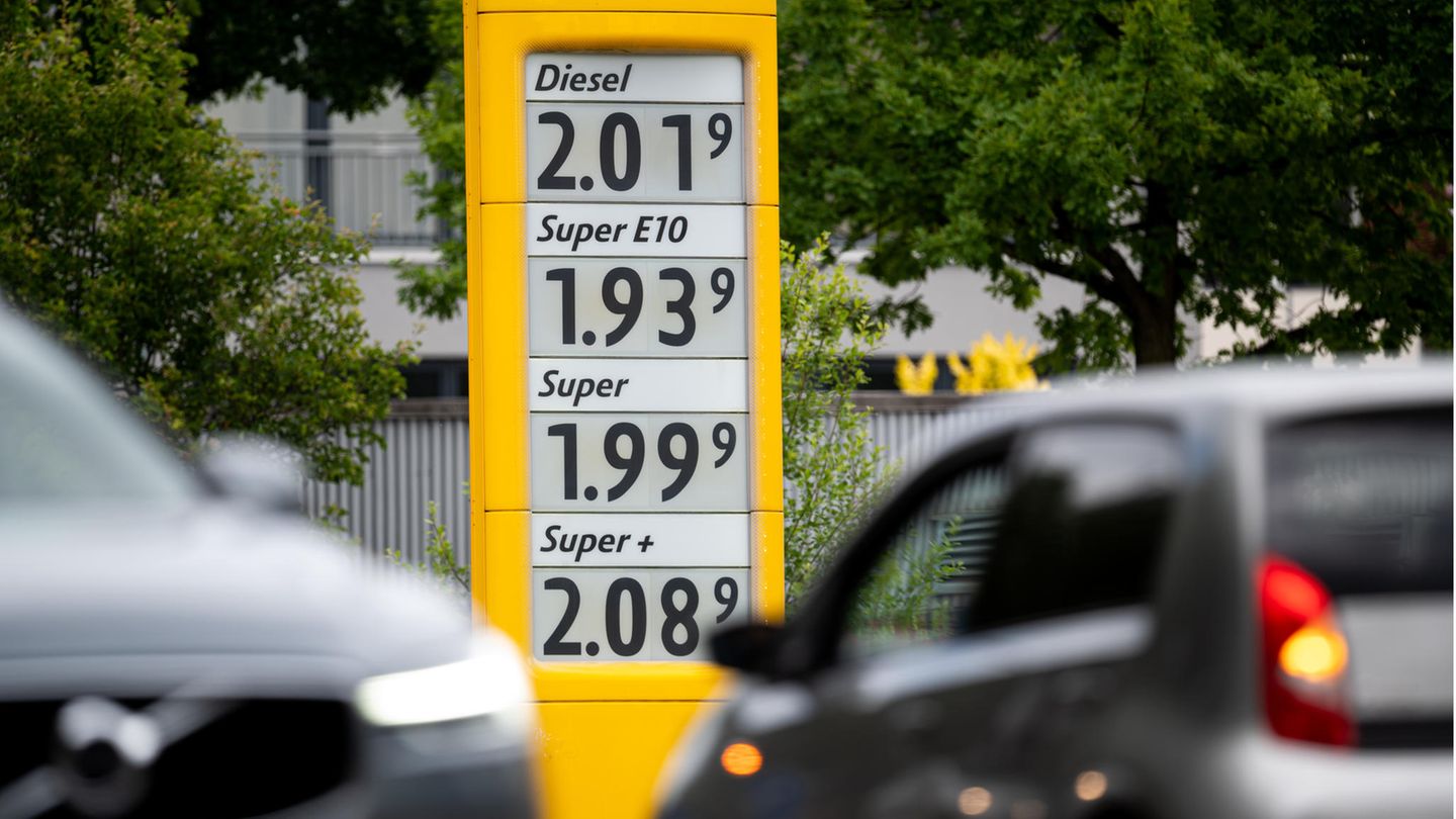 Tankrabatt: Eine Anzeigetafel an einer Tankstelle zeigt die Preise für Kraftstoffe, im Vordergrund sind Autos