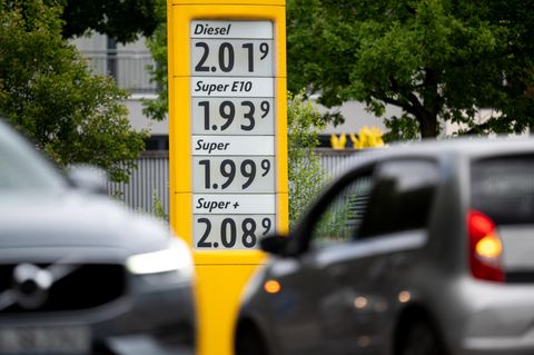 Tankrabatt: Eine Anzeigetafel an einer Tankstelle zeigt die Preise für Kraftstoffe, im Vordergrund sind Autos