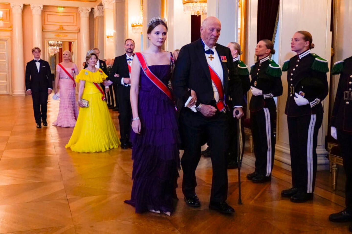 Nach der Fotosession ging es zum Galadinner. Ingrid Alexandra erschien in einem dunkelvioletten Volantkleid von Alberta Ferretti, das einst ihrer Mutter Mette-Marit gehörte. König Harald geleitete die Prinzessin in den Speisesaal des Osloer Schlosses. Zur Feier des Tages trug die Erbprinzessin ein geerbtes Diadem ihrer Ururgroßmutter Prinzessin Ingeborg von Schweden.