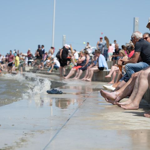 Menschen sitzen an einem Wasserbecken
