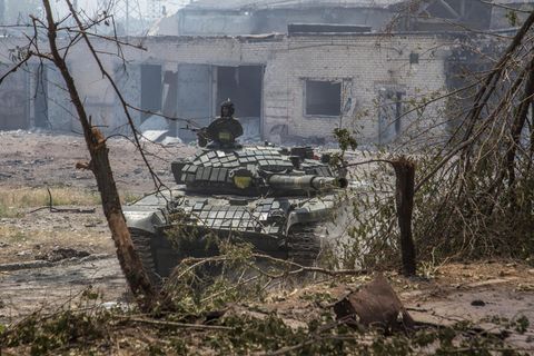 Ein Soldat hält sein Gewehr auf einem ukrainischen Panzer