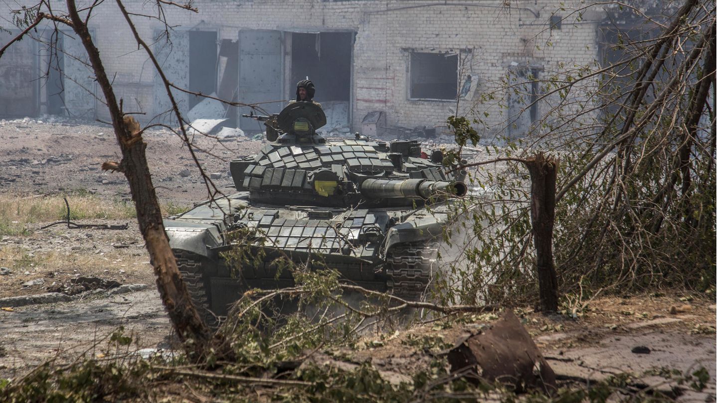 Ein Soldat hält sein Gewehr auf einem ukrainischen Panzer