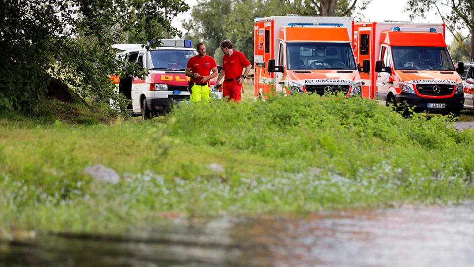 Rettungskräfte stehen an einem See