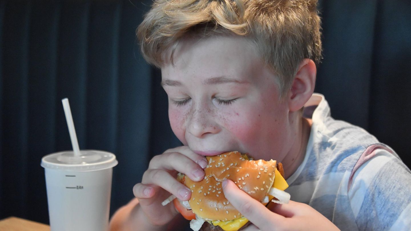 Ein Kind mit Fast Food. Werbung dafür soll es bald nicht mehr geben.