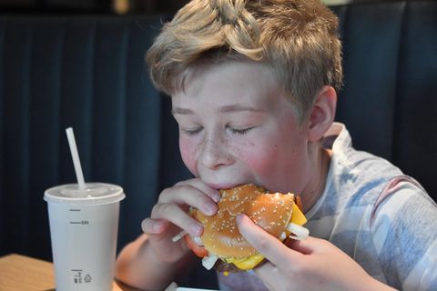 Ein Kind mit Fast Food. Werbung dafür soll es bald nicht mehr geben.