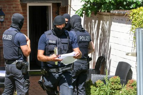 Bundespolizisten stehen vor einer Wohnung