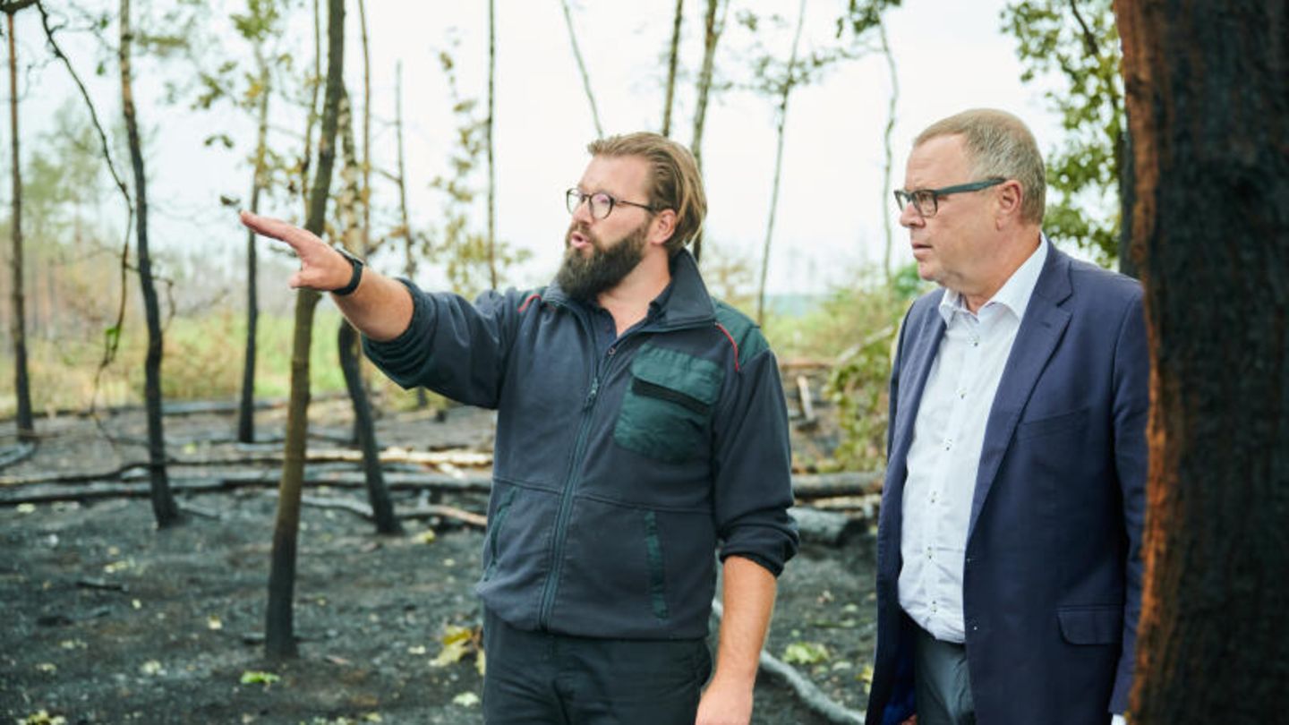 Kevin Grigorian (l.), Einsatzleitung Feuerwehr, erklärt Brandenburgs Innenminister Michael Stübgen (CDU) vor Ort die Lage