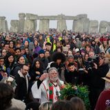 Arthur Uther Pendragon (vorne,M) schließt sich den Menschen an, die bei Sonnenaufgang am Heel Stone versammeln
