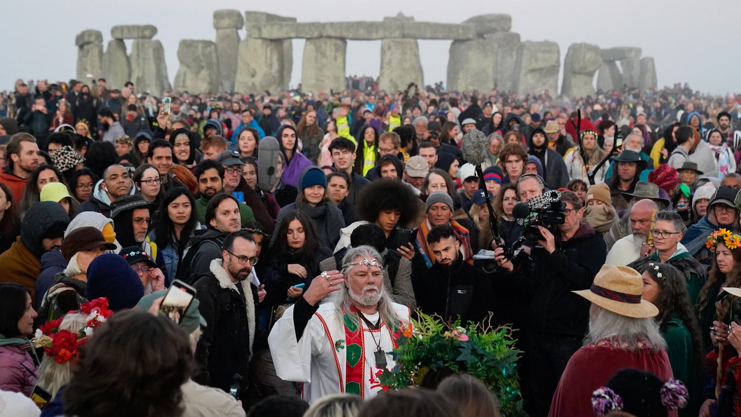 Arthur Uther Pendragon (vorne,M) schließt sich den Menschen an, die bei Sonnenaufgang am Heel Stone versammeln