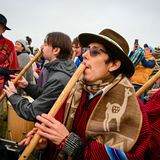 Menschen spielen in Stonehenge Flöte