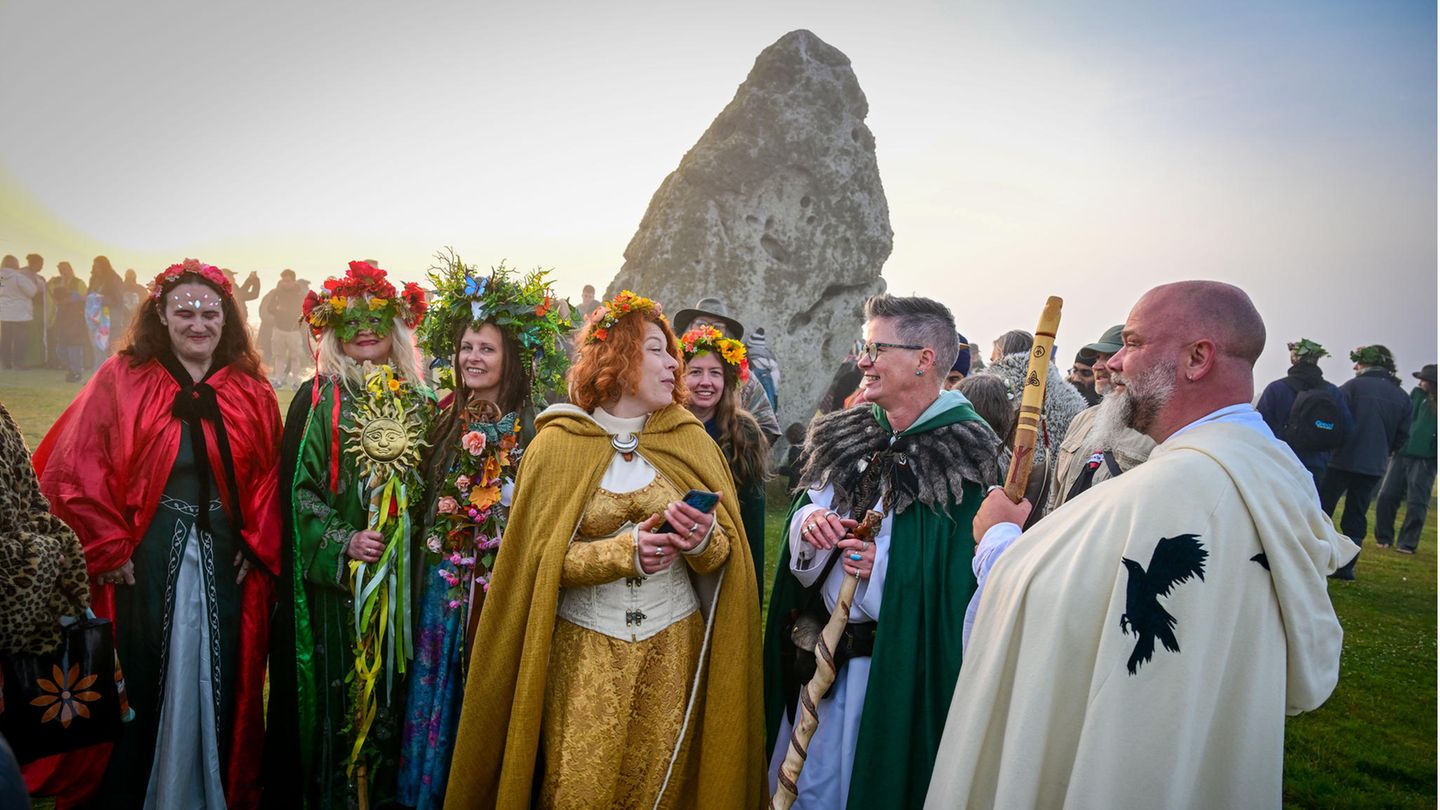 Menschen in Verkleidungen stehen in Stonehenge
