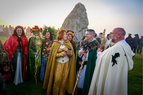 Menschen in Verkleidungen stehen in Stonehenge